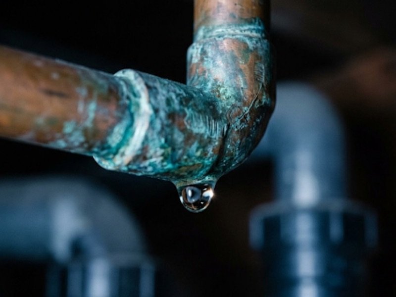 Water droplet forming on a copper pipe joint under a sink